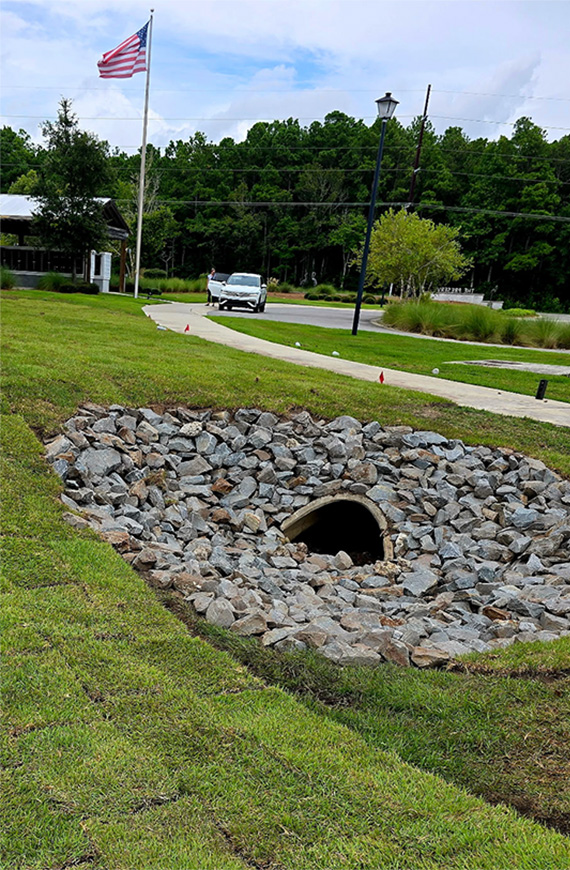Riprap drainage basin with a reinforced culvert engineered to improve stormwater flow and protect surrounding landscape from erosion.