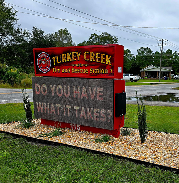 Decorative stone landscape bed with ornamental plants installed around the Turkey Creek Fire and Rescue Station entrance sign.