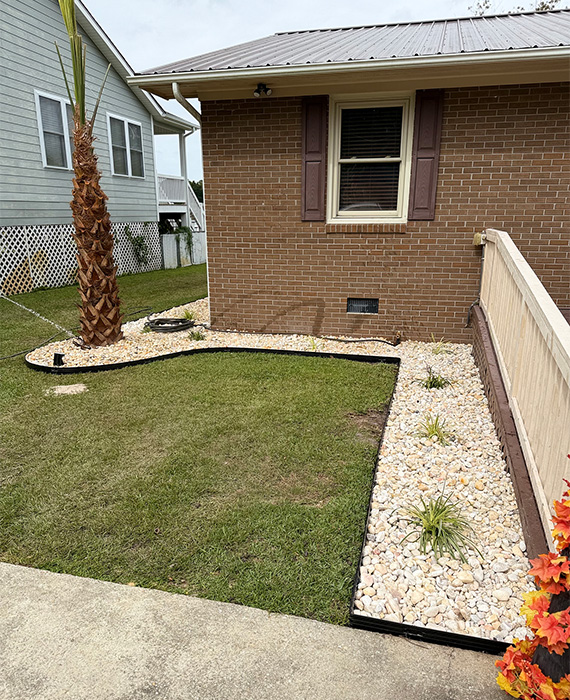Professionally designed landscape featuring newly installed turf, irrigation sprinklers, mulch beds, and clean landscape edging for lasting curb appeal.